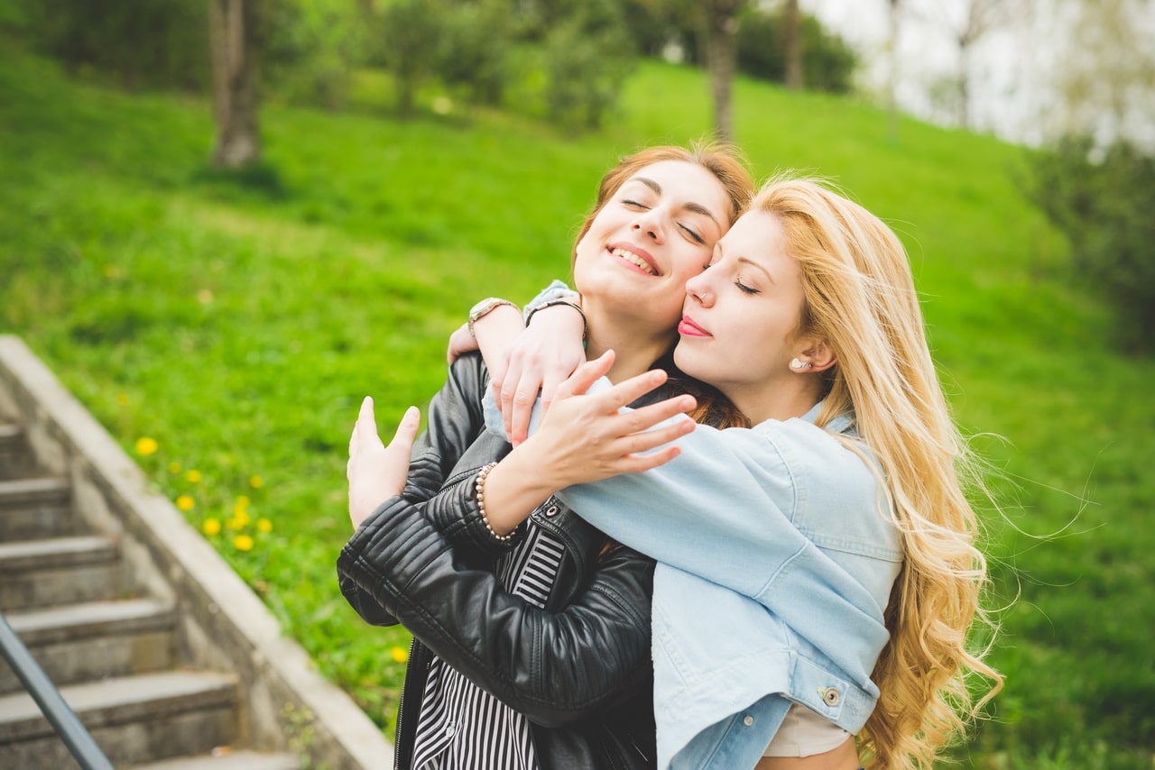 Two Beautiul Blonde And Brunette Girl Having Fun In A City Park
