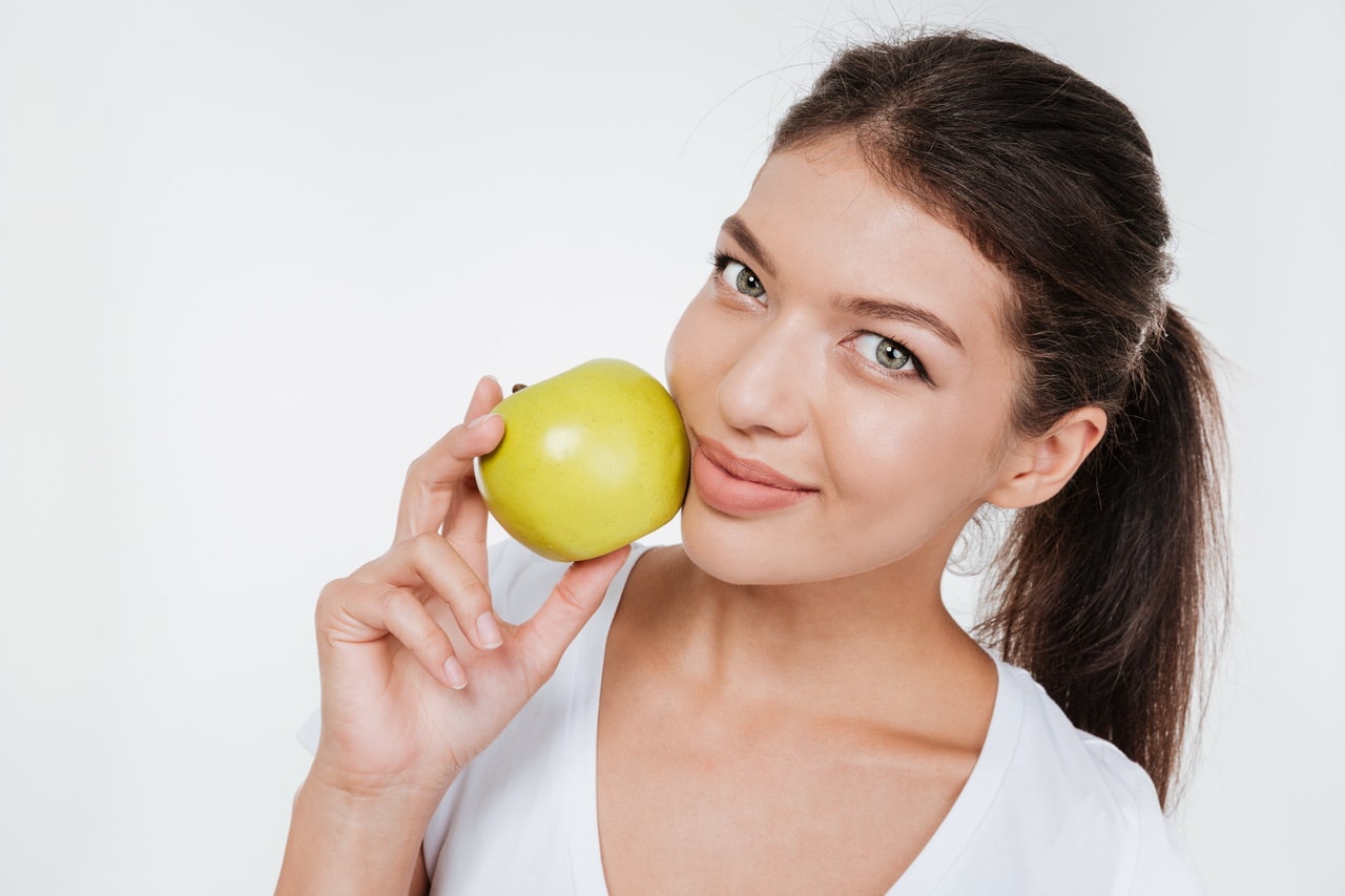 Happy Woman Holding Apple Near Face